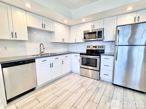 A kitchen with white cabinets and stainless steel appliances.