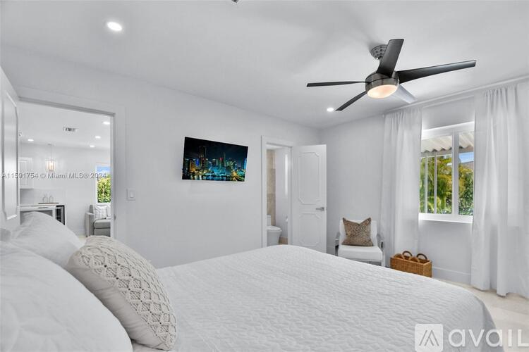 A bedroom with a large bed and a ceiling fan.