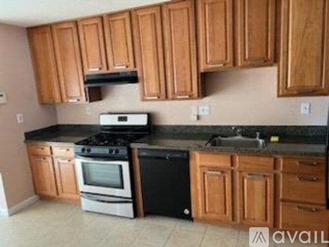 A kitchen with wooden cabinets and black countertops.