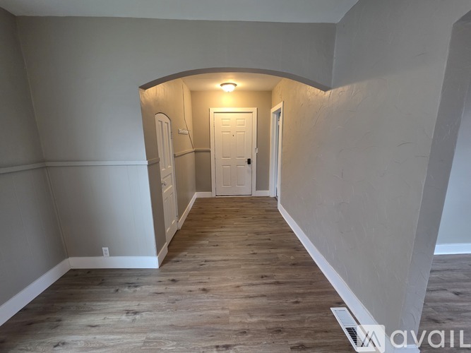 A room with wooden flooring and a white door.