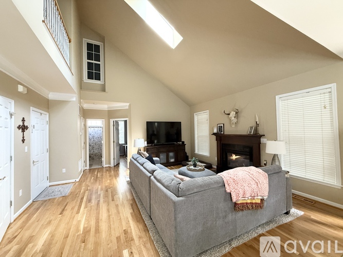 A living room with a grey couch and a fireplace.