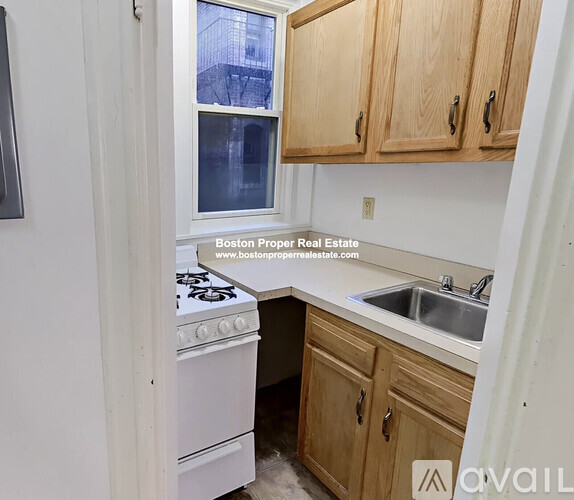 A kitchen with wooden cabinets and a white stove top oven.