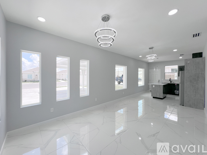 A spacious, well-lit room with a marble floor and a large mirror on the wall.