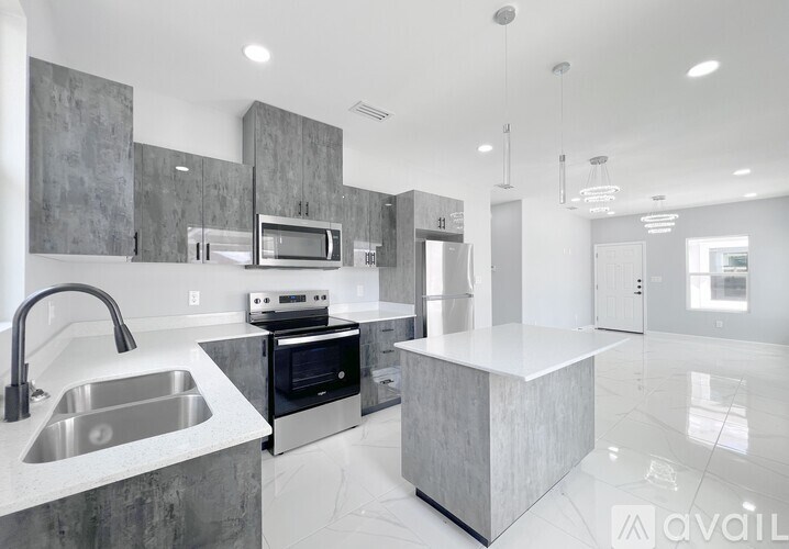 A modern kitchen with a stainless steel sink and a microwave above it.