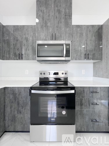 A modern kitchen with a stove and microwave above it.