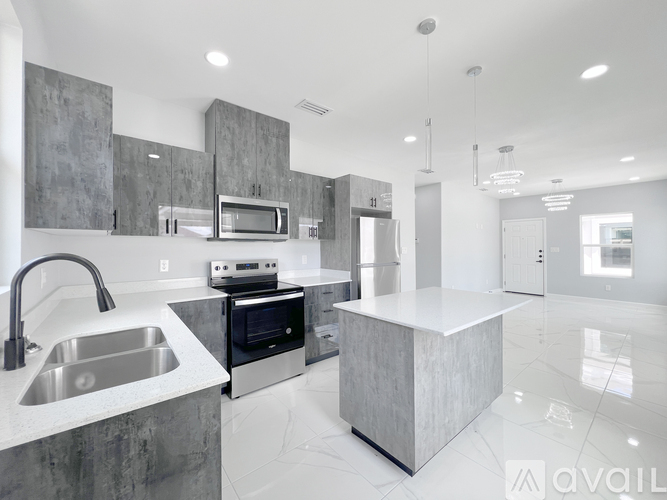A modern kitchen with a stainless steel sink and countertop.