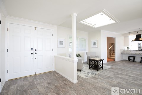 A spacious living room with a white sofa and a wooden coffee table.