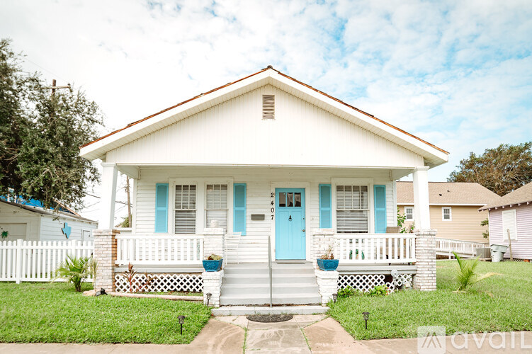 A white house with a blue door and steps leading to the front door.