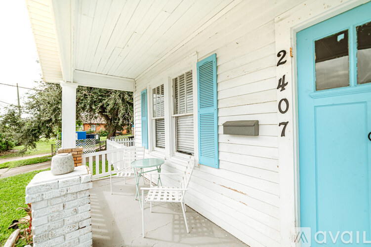 A white house with a blue door and a number 2407 on the wall.