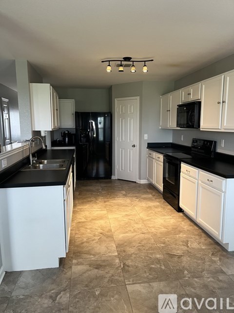 A kitchen with black countertops and white cabinets.