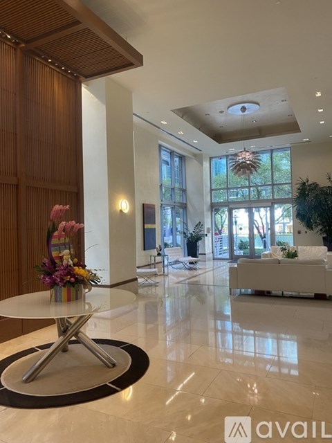 A modern living room with a white coffee table and a large window.