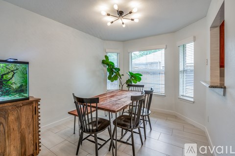 A dining room with a wooden table and chairs.