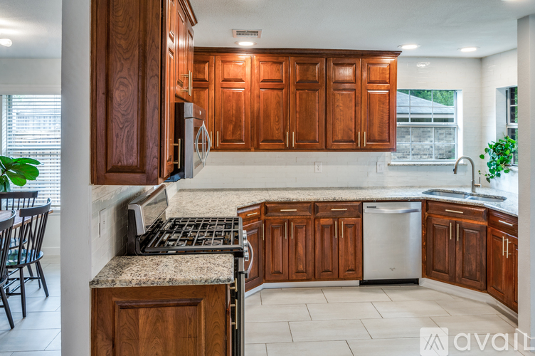 A kitchen with wooden cabinets and a granite countertop.