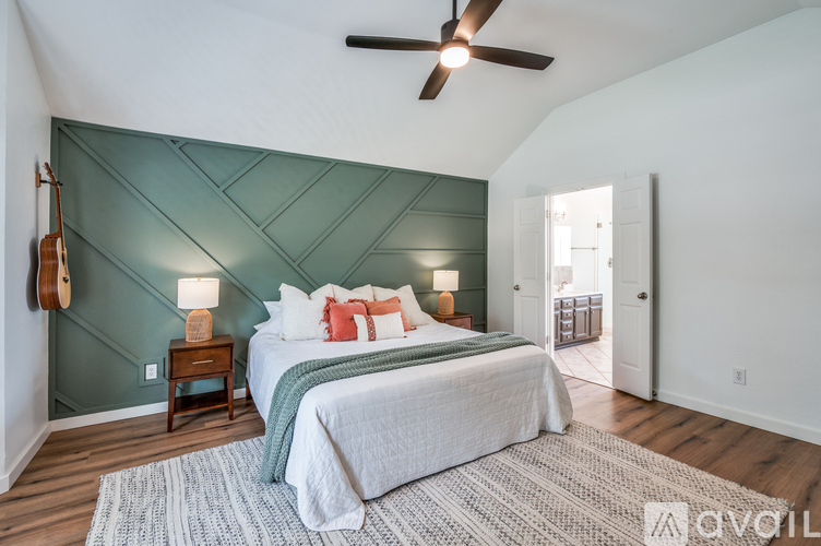 A bedroom with a bed, a ceiling fan, and a rug.