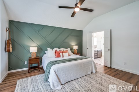 A bedroom with a bed, a ceiling fan, and a rug.