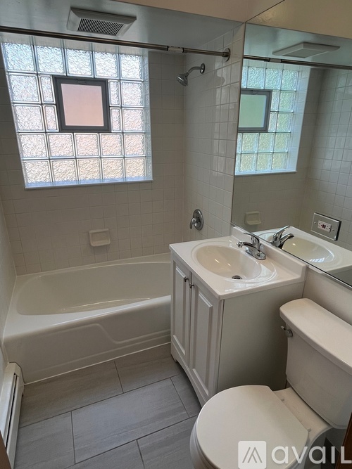 A bathroom with a tub, toilet, and sink.