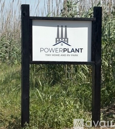 A sign for Powerplant Tiny Home and RV Park stands in a field.