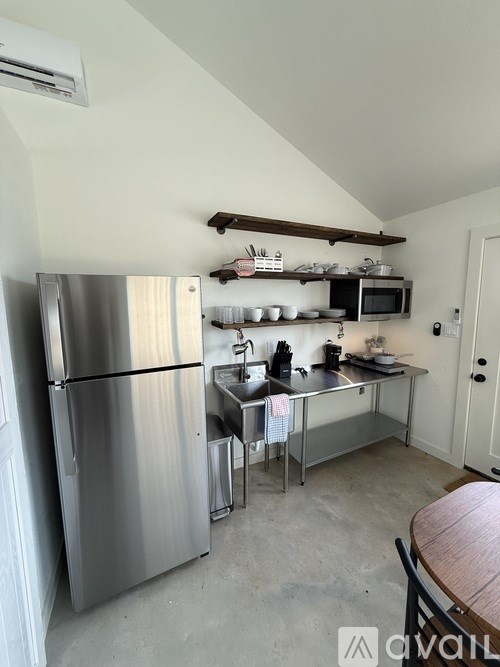 A kitchen with a stainless steel refrigerator and a microwave on the counter.