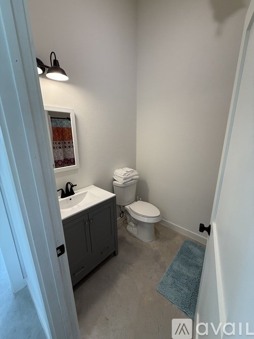 A bathroom with a toilet, sink, and cabinet.
