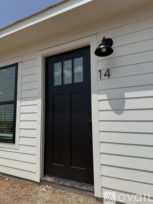 A black door with a number 14 on the wall above it.