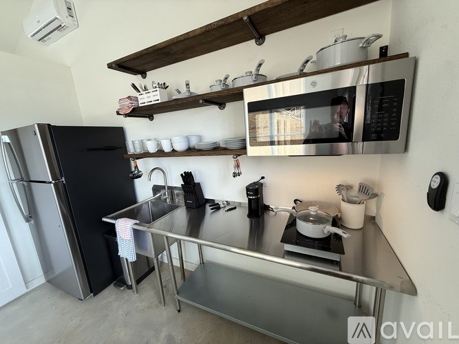A modern kitchen with a stainless steel refrigerator and microwave above a stove.