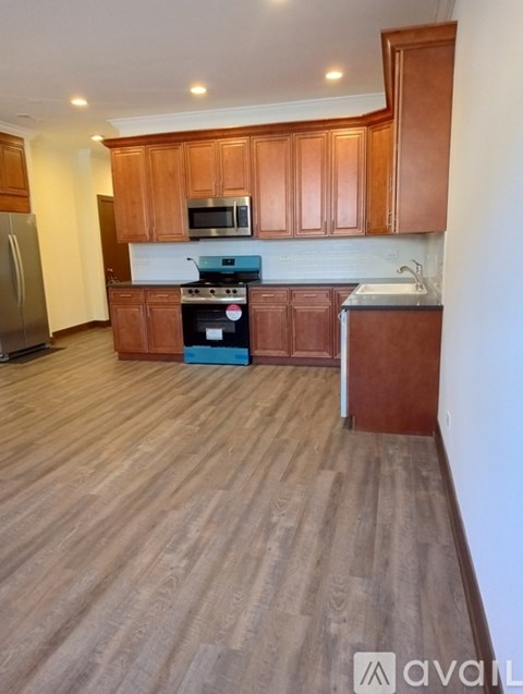 A kitchen with wooden cabinets and a refrigerator.
