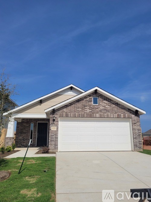 A house with a garage door and a driveway in front.