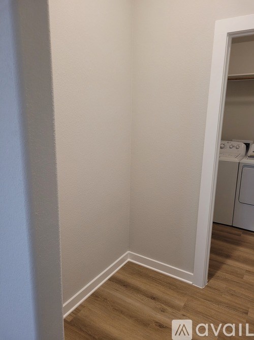 A white wall with a doorway leading to a laundry room.