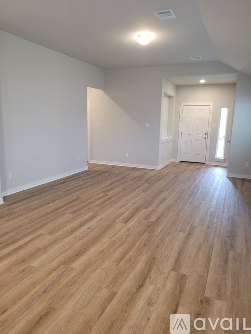 A room with wooden flooring and white walls.