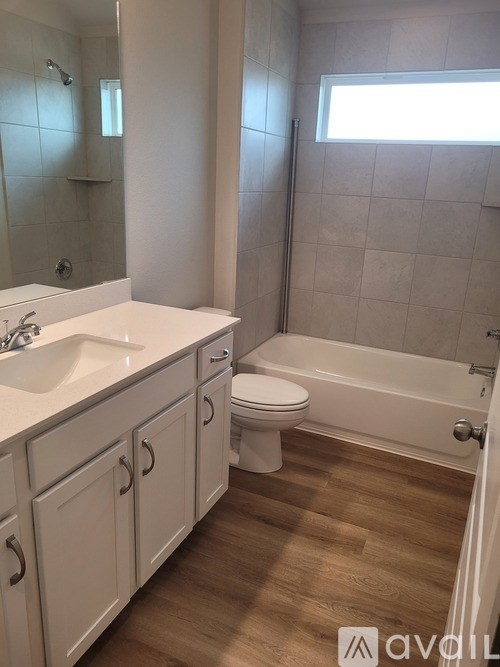 A bathroom with a white sink, toilet, and bathtub.
