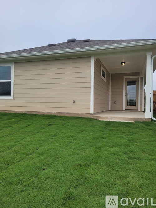 A house with a brown roof and a green lawn.