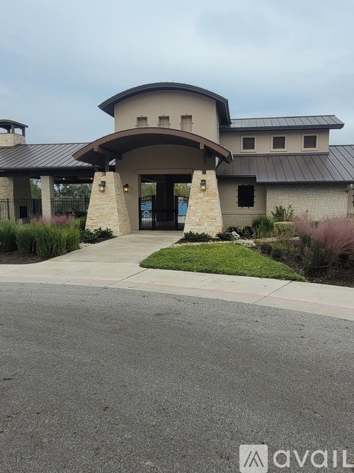 A modern building with a curved entrance and a stone pillar.
