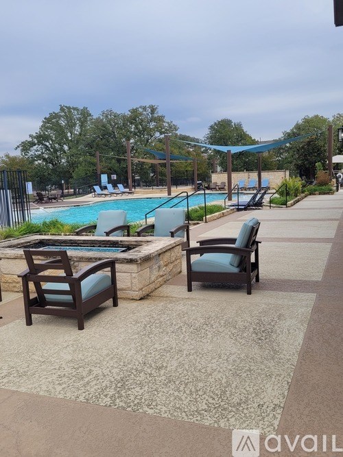 Two chairs are placed on a patio next to a pool.