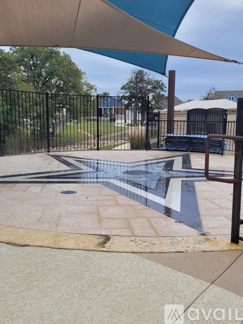 A pool area with a black fence and a blue umbrella.