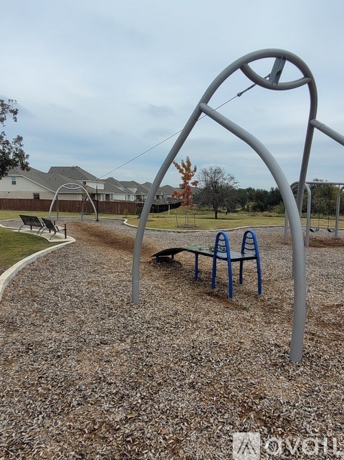 A playground with a swing set and a blue slide.