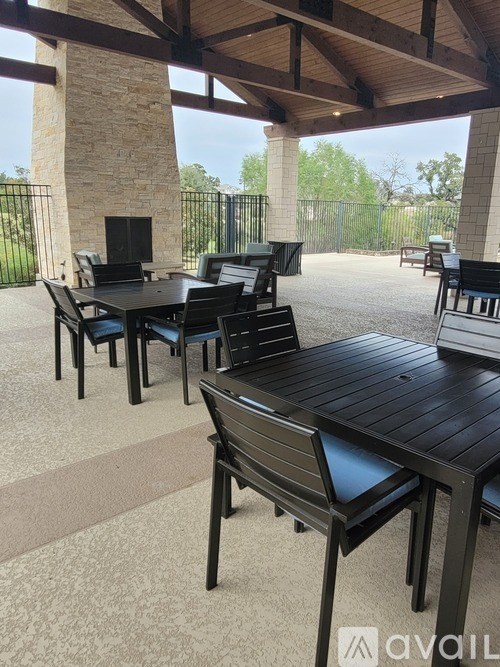 A patio with a table and chairs and a stone pillar.