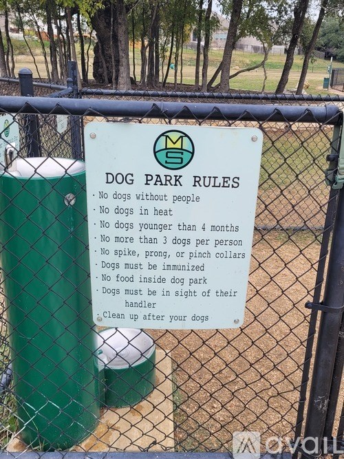 A sign on a fence lists the rules for a dog park.