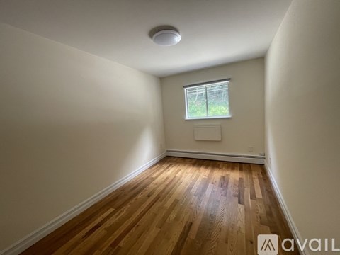 A room with wooden flooring and a window.