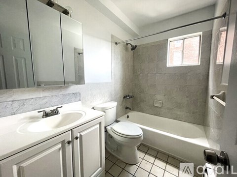 A white bathroom with a toilet, sink, and bathtub.