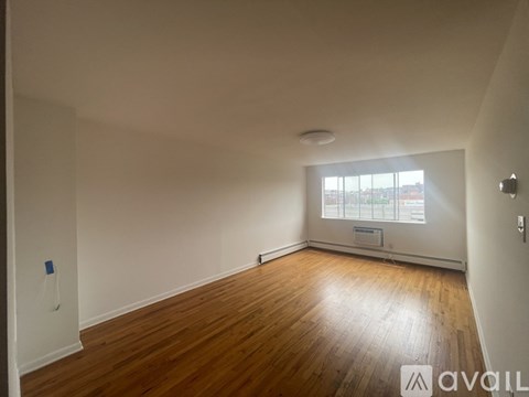 A room with wooden flooring and a ceiling fan.