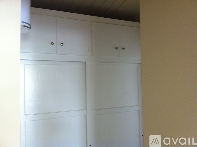 A white cupboard with two doors and two drawers is in a room.