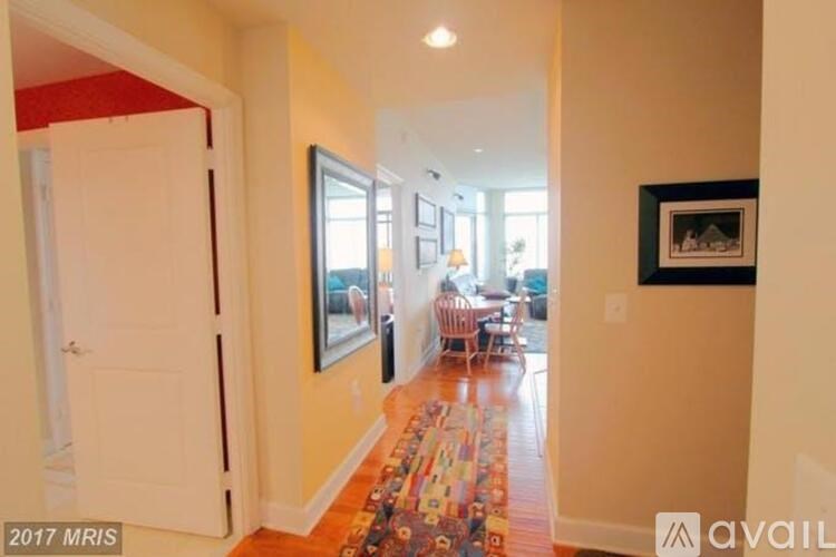 A hallway with a framed picture on the wall and a rug on the floor.
