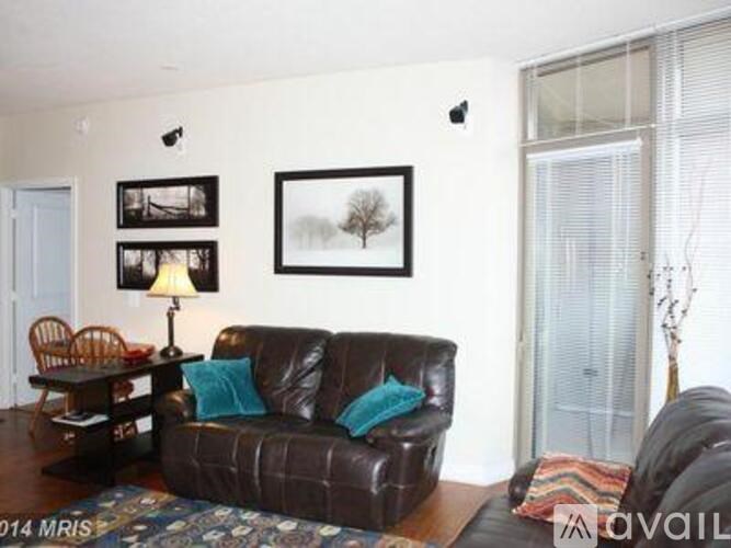 A living room with a brown leather couch and a wooden table.
