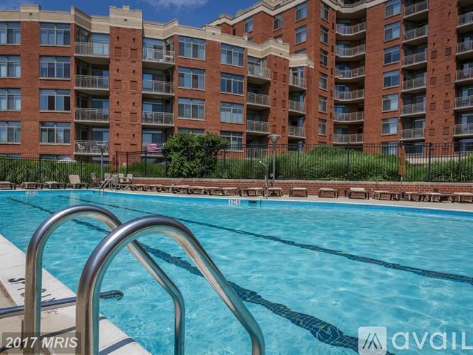 A swimming pool in front of a red brick apartment building.