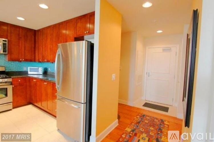 A kitchen with wooden cabinets and a stainless steel refrigerator.