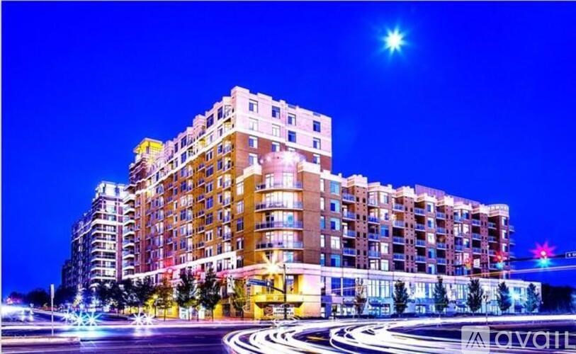 A large building with many windows is lit up at night.