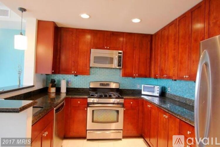 A kitchen with wooden cabinets and a stainless steel refrigerator.