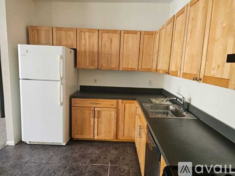 A kitchen with wooden cabinets and a white refrigerator.