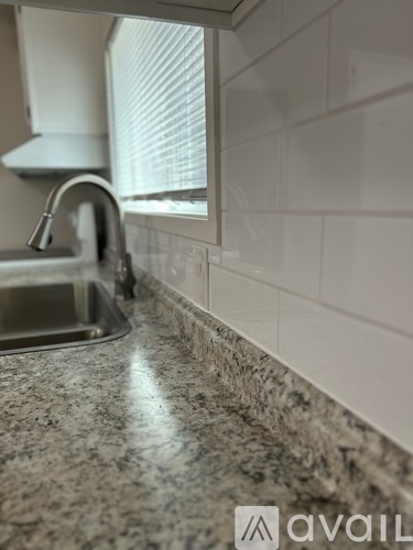A kitchen counter with a sink and a granite countertop.