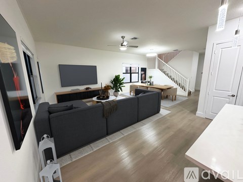 A living room with a grey sofa and a television on the wall.
